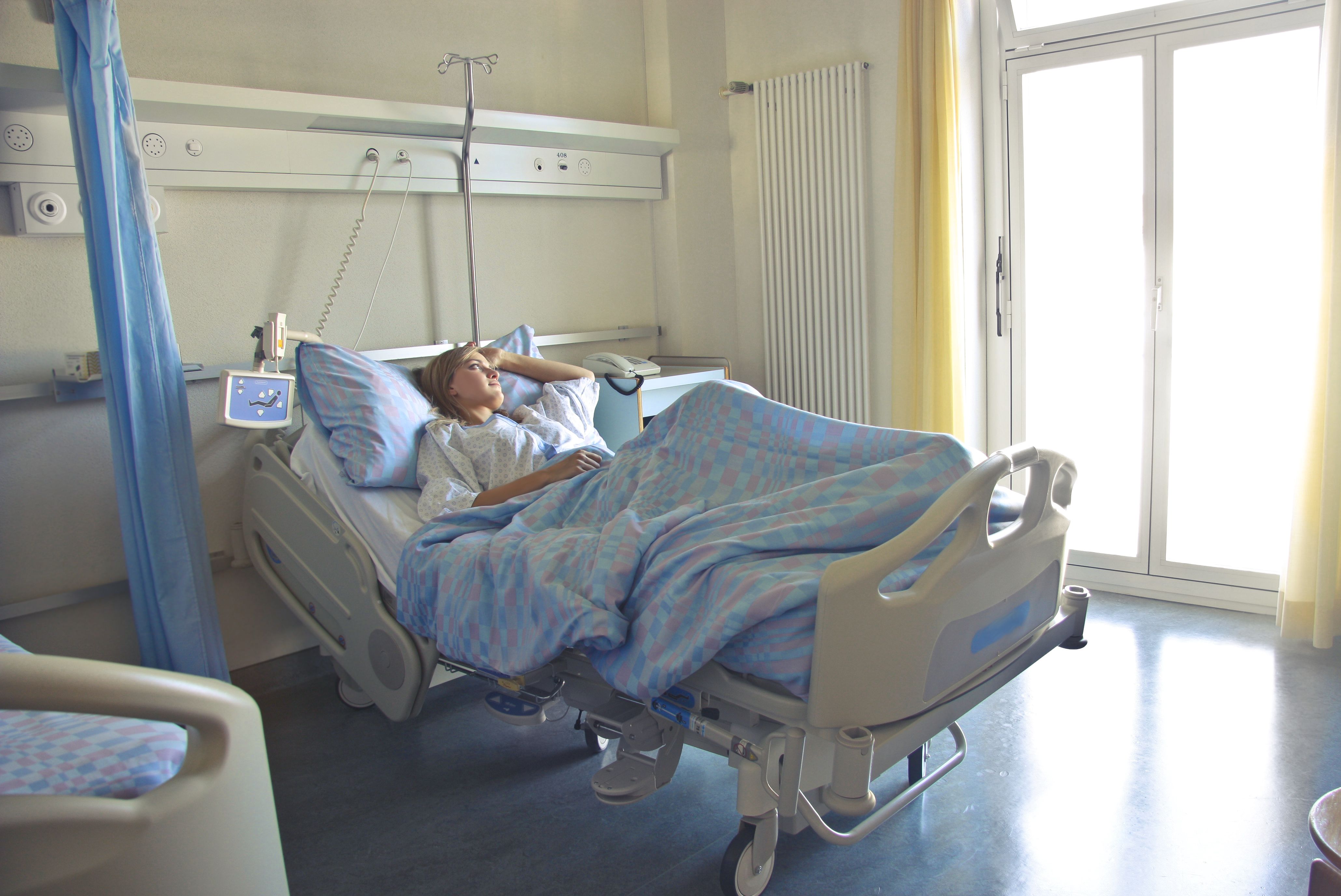 Patient resting in a hospital bed by a sunlit window