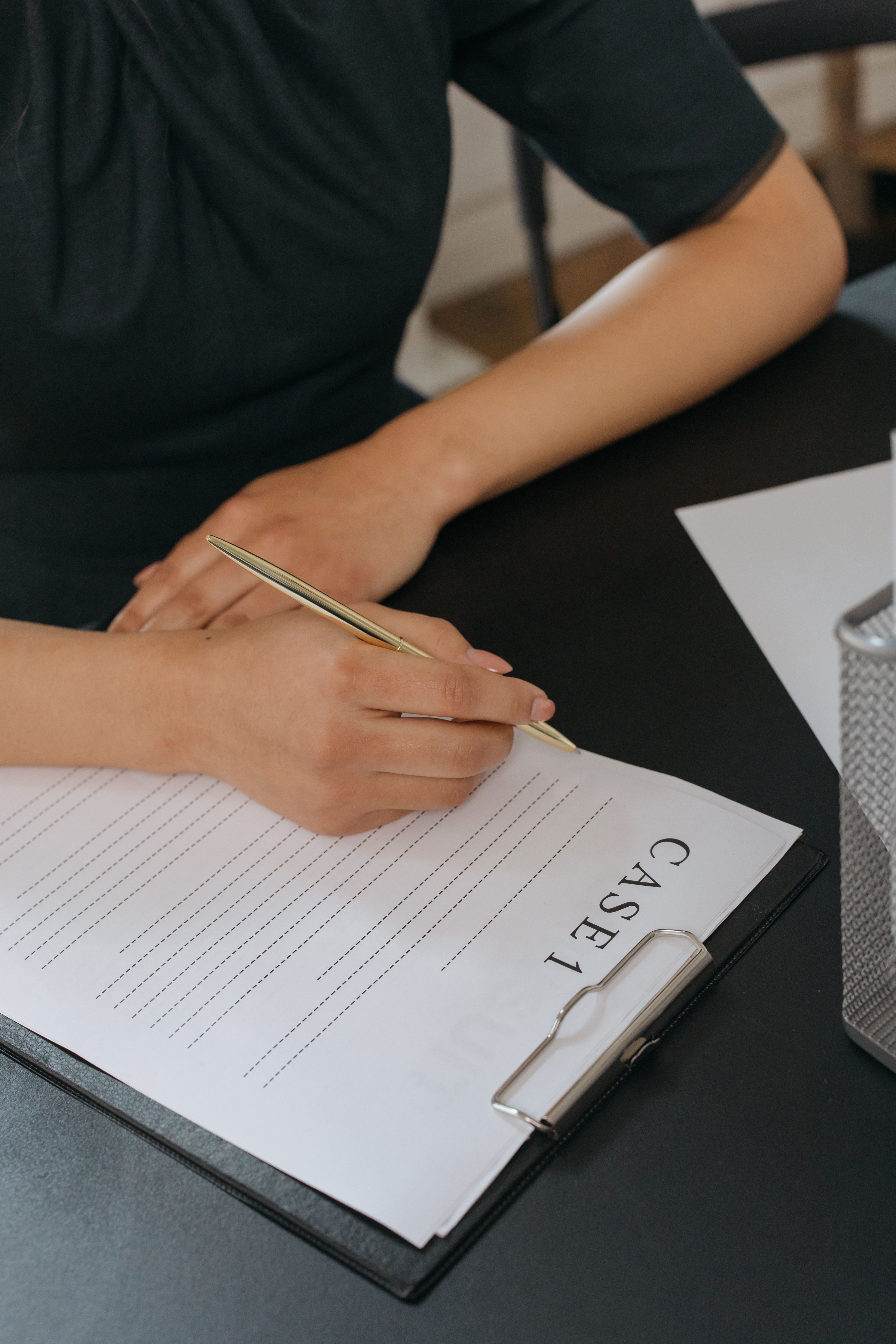 Person writing notes on a case document at a desk